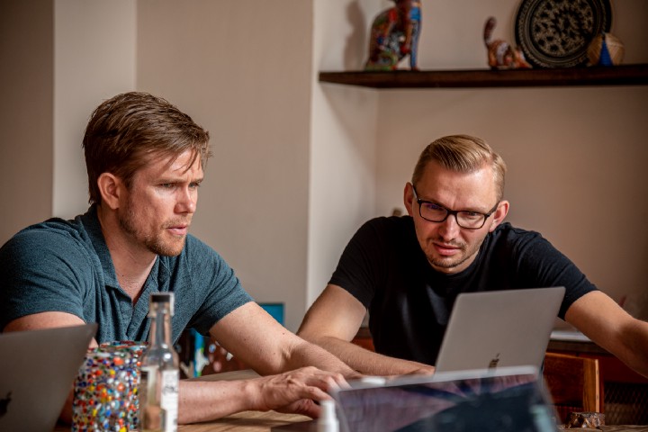 Two person discussing looking at a laptop